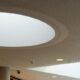 Perforated ceiling with a large circular skylight inside a modern public building
